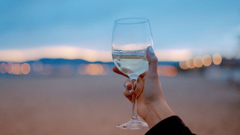 Glas Weißwein vor unscharfem Hintergrund